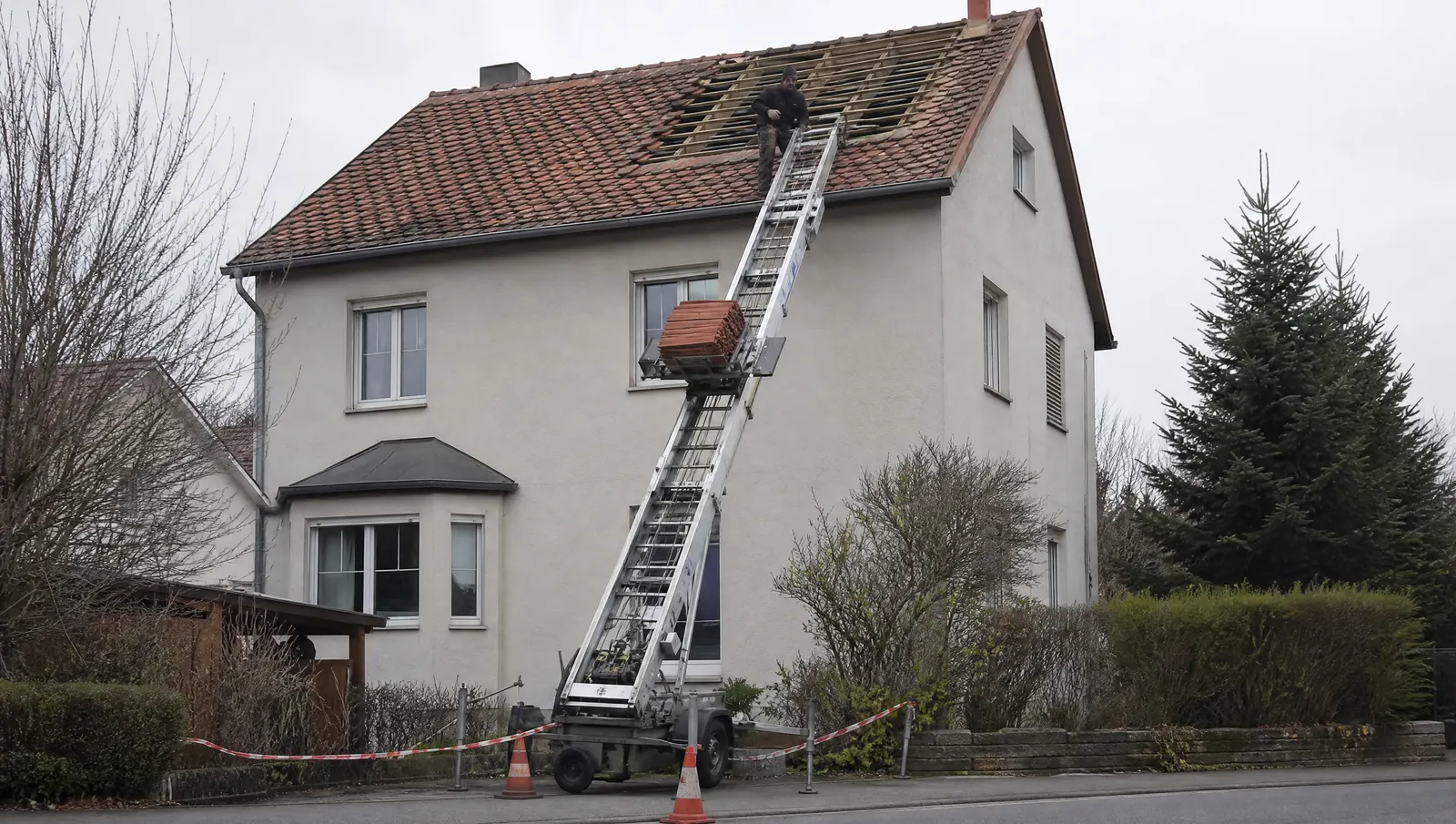 Schrägaufzug transportiert Dachziegel auf ein Hausdach