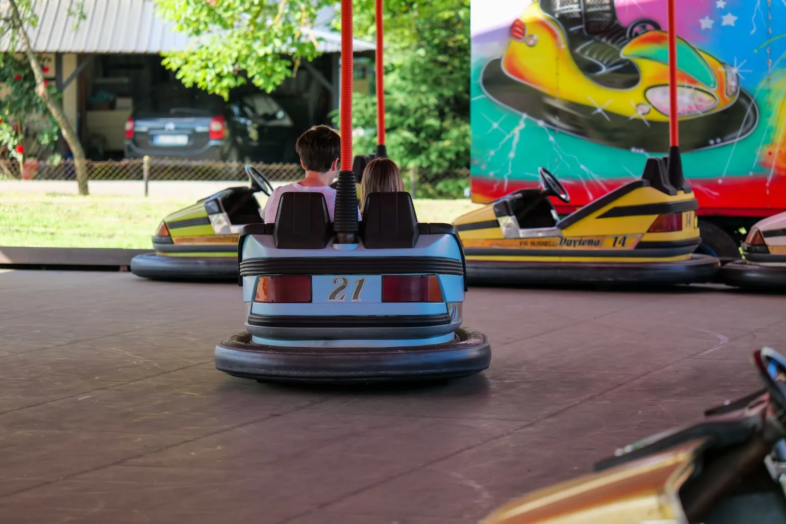 Kids having fun on bumper cars at Garešnica fairground. Exciting entertainment activity outdoors.